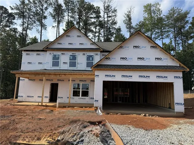 Two-story exterior with a covered porch, multiple windows, and an integrated garage