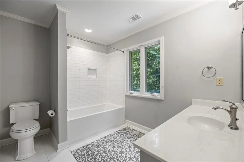 Full bathroom featuring shower / bath combination, vanity, light tile patterned floors, crown molding, and recessed lighting