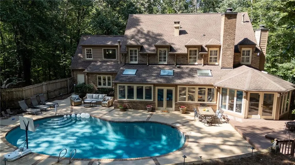 Back of property featuring a sunroom, an outdoor hangout area, a patio area, and a chimney