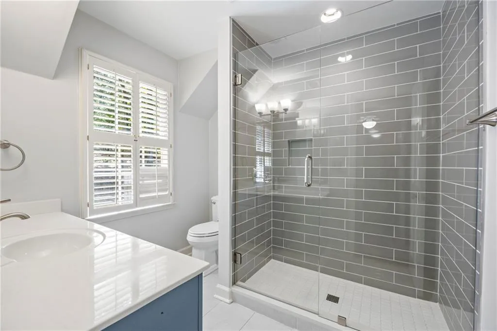 Bathroom with vanity, a stall shower, and light tile patterned floors