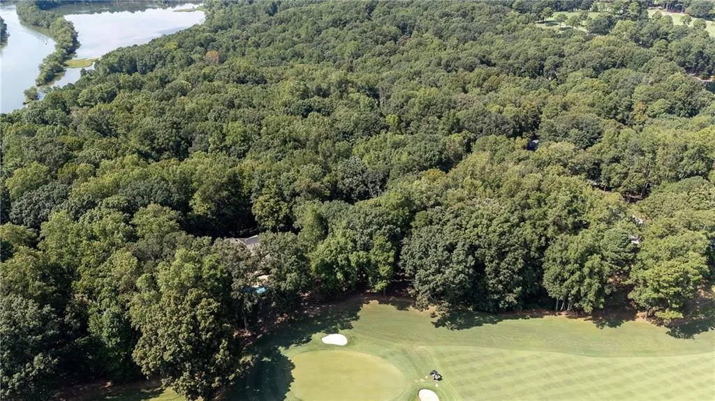 Aerial view of property and surrounding area with a golf club
