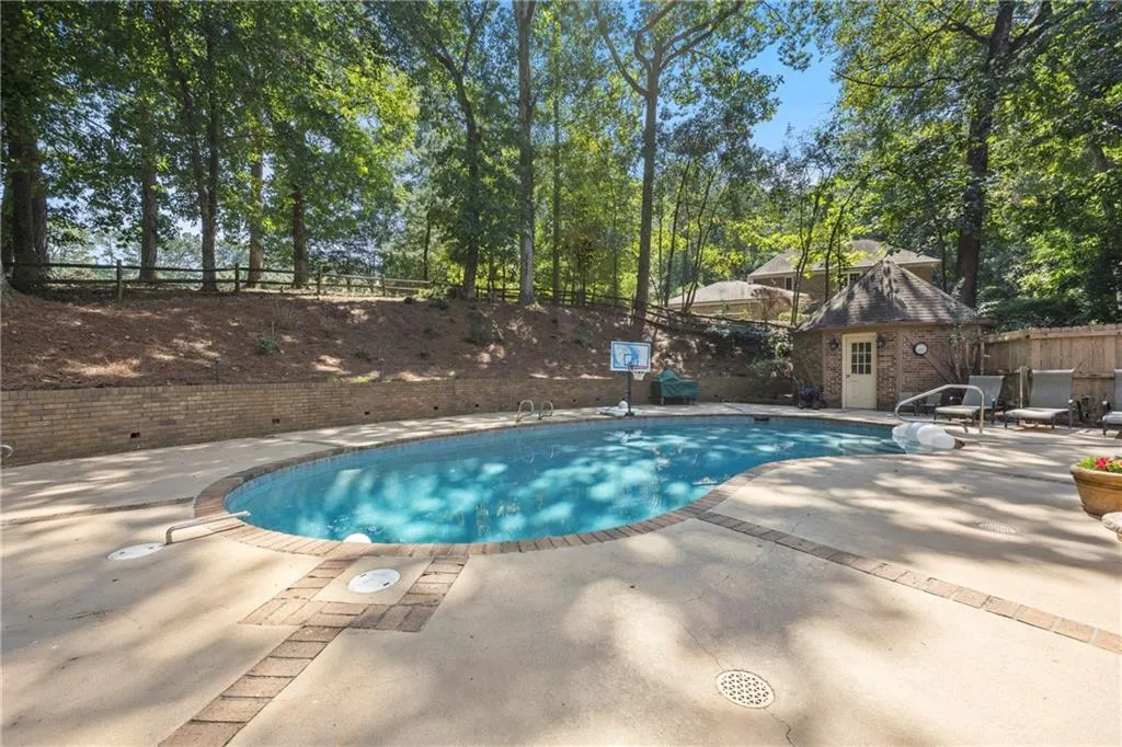 View of swimming pool with a fenced backyard, a patio, and an outbuilding