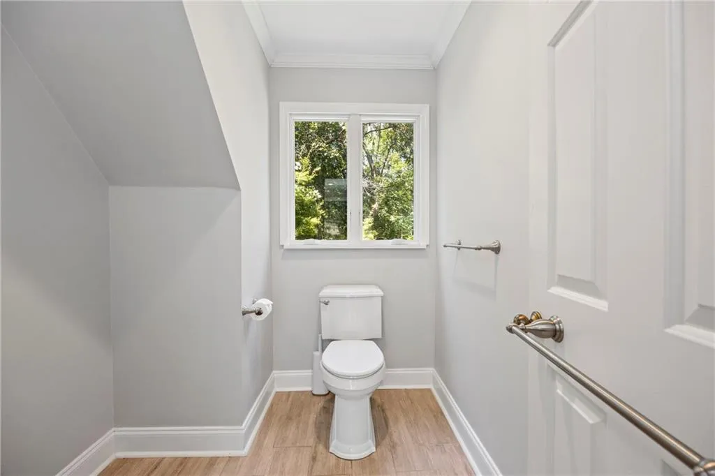 Bathroom with crown molding and light wood finished floors