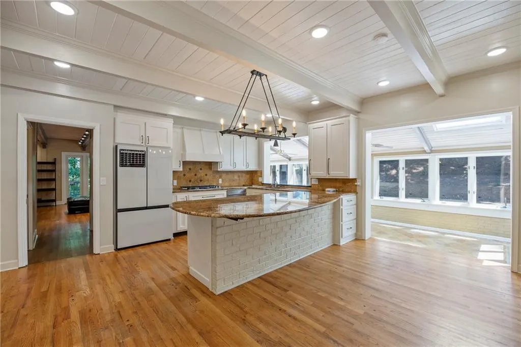 Kitchen featuring white cabinets, backsplash, light wood-type flooring, white refrigerator, and recessed lighting