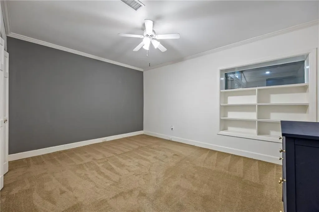 Unfurnished room with crown molding, light colored carpet, and ceiling fan