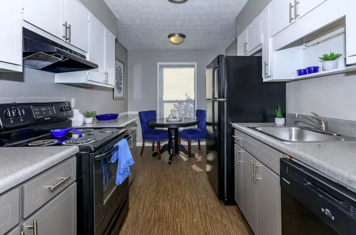 Kitchen with white cabinets, black appliances, dark hardwood / wood-style flooring, and sink