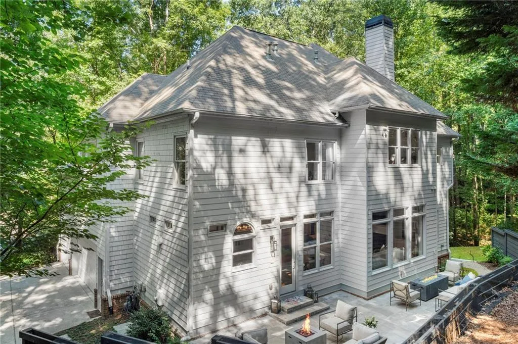 Rear view of house with an outdoor living space with a fire pit, a patio area. Rear view of house with an outdoor living space with a fire pit, a patio area.
