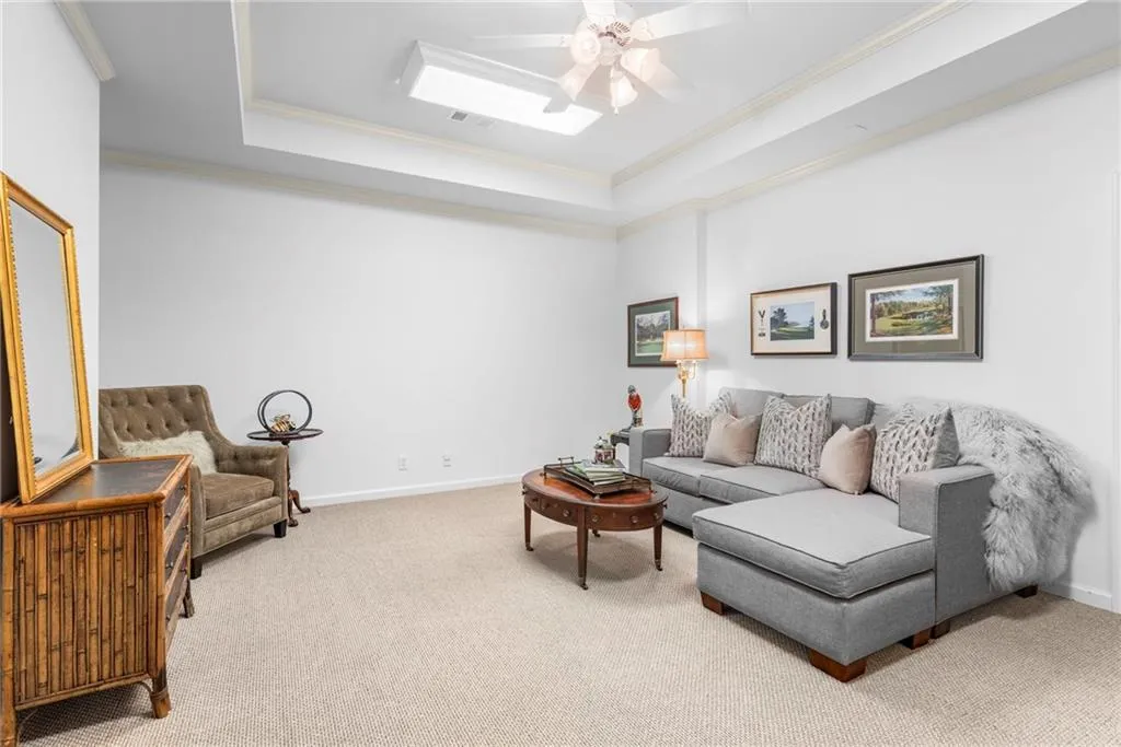 Terrace-level media or family room with tray ceiling, ceiling fan, and kitchenette Terrace-level media or family room with tray ceiling, ceiling fan, and kitchenette