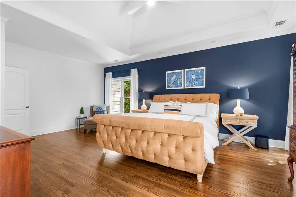 Primary Bedroom featuring sitting area,10’ ceiling with tray, ornamental molding, recessed lighting, ceiling fan and hardwood floors Primary Bedroom featuring sitting area,10’ ceiling with tray, ornamental molding, recessed lighting, ceiling fan and hardwood floors