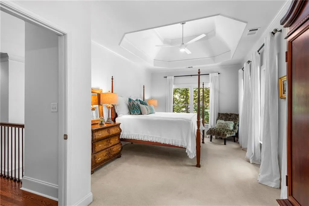 Secondary Guest Bedroom ensuite featuring 10’ ceiling with tray, ceiling fan, ornamental molding with generous walk-in closet Secondary Guest Bedroom ensuite featuring 10’ ceiling with tray, ceiling fan, ornamental molding with generous walk-in closet