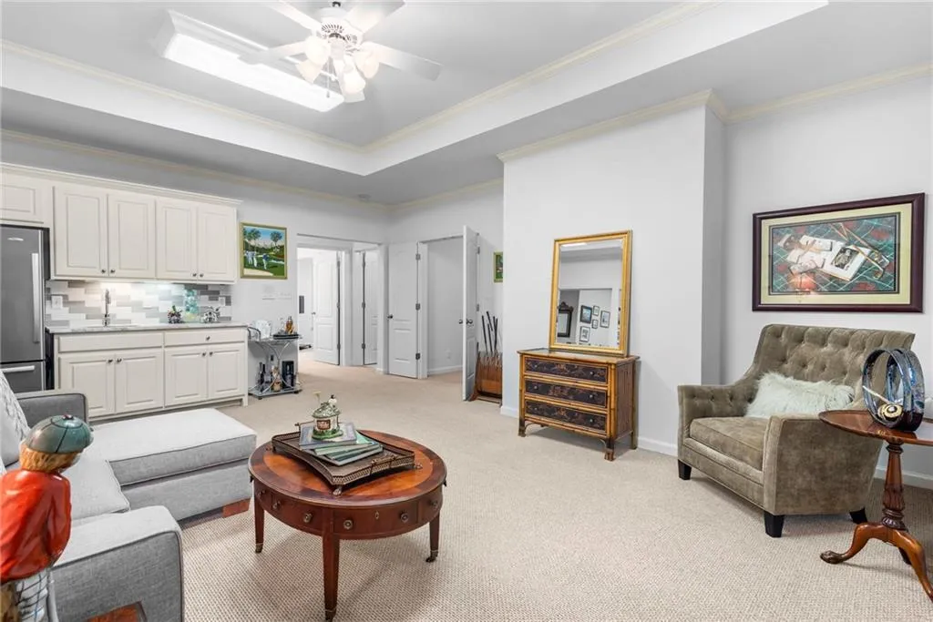 Terrace-level media or family room with tray ceiling, ceiling fan, and kitchenette Terrace-level media or family room with tray ceiling, ceiling fan, and kitchenette
