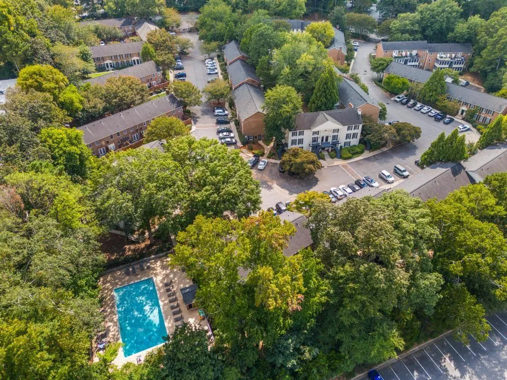 Bird's eye view of a tree filled landscape and a pool area