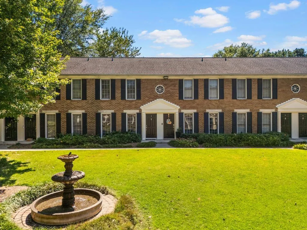 Colonial-style house featuring a front lawn and brick siding