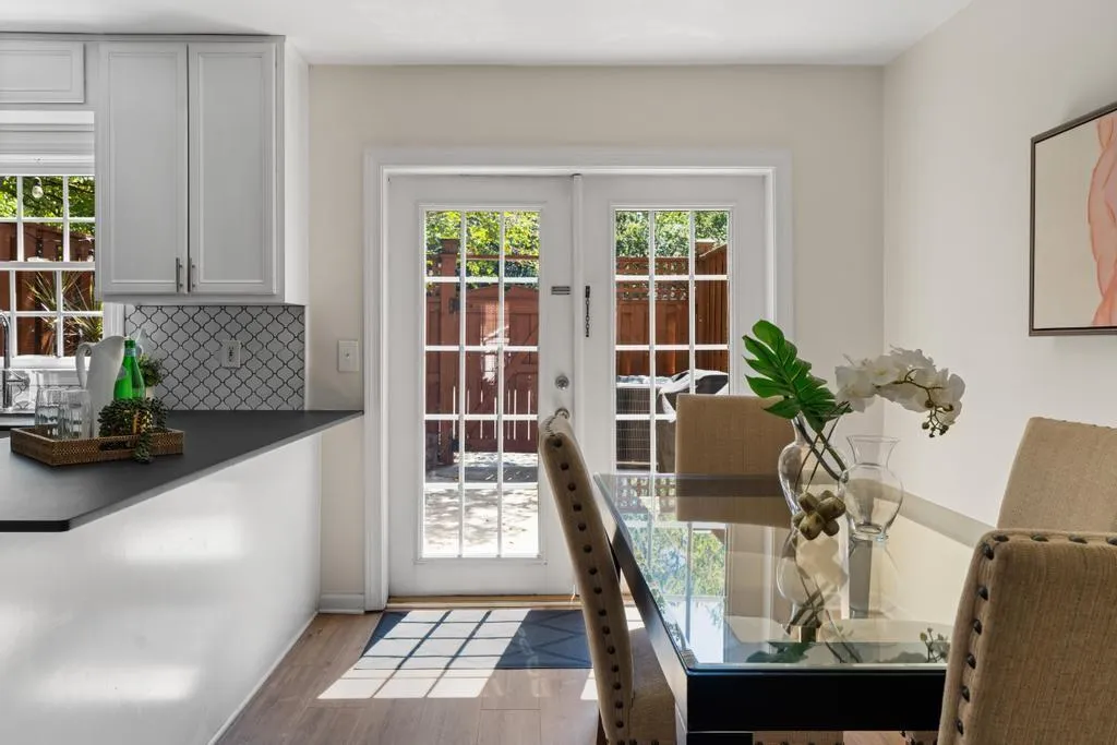 Doorway with healthy amount of natural light, wood finished floors, and french doors