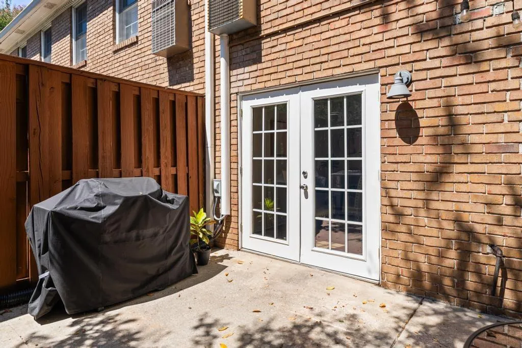 Property entrance featuring a patio, french doors, and brick siding