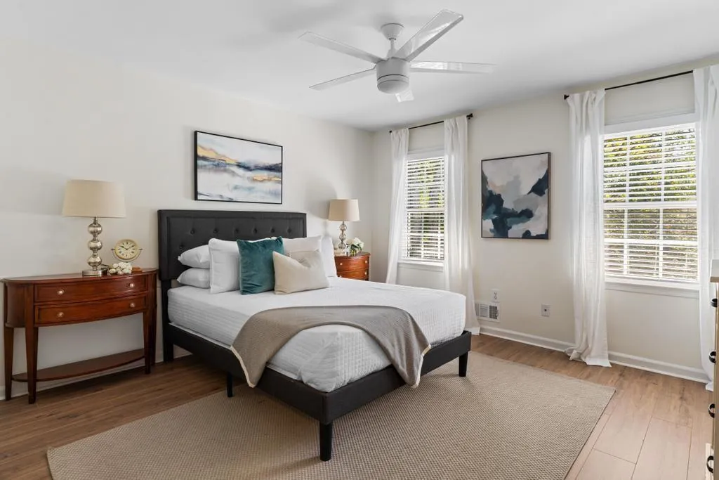 Bedroom featuring multiple windows, wood finished floors, and ceiling fan