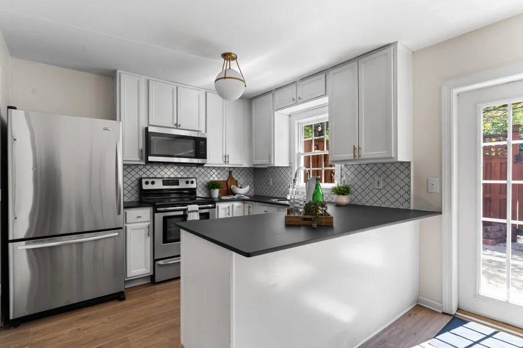 Kitchen with stainless steel appliances, plenty of natural light, dark wood-type flooring, and backsplash