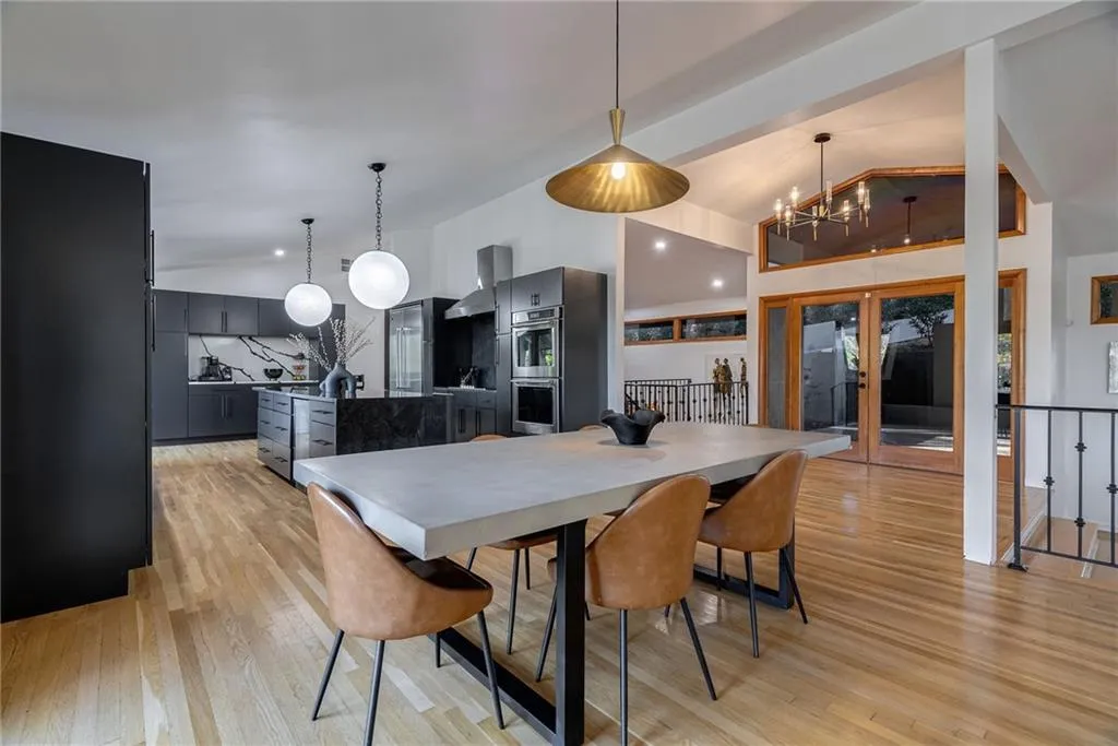 Dining room with french doors, vaulted ceiling, light hardwood / wood-style floors, and an inviting chandelier