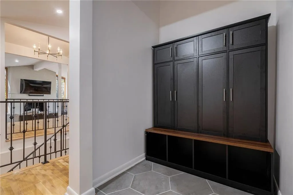 Mudroom with a chandelier, hardwood / wood-style floors, and vaulted ceiling