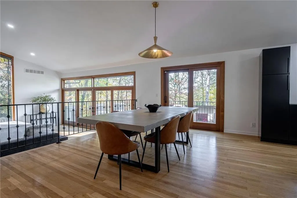 Dining space with light hardwood / wood-style floors and vaulted ceiling