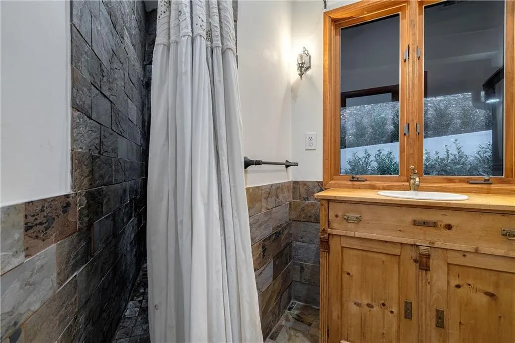 Bathroom featuring vanity and tile walls