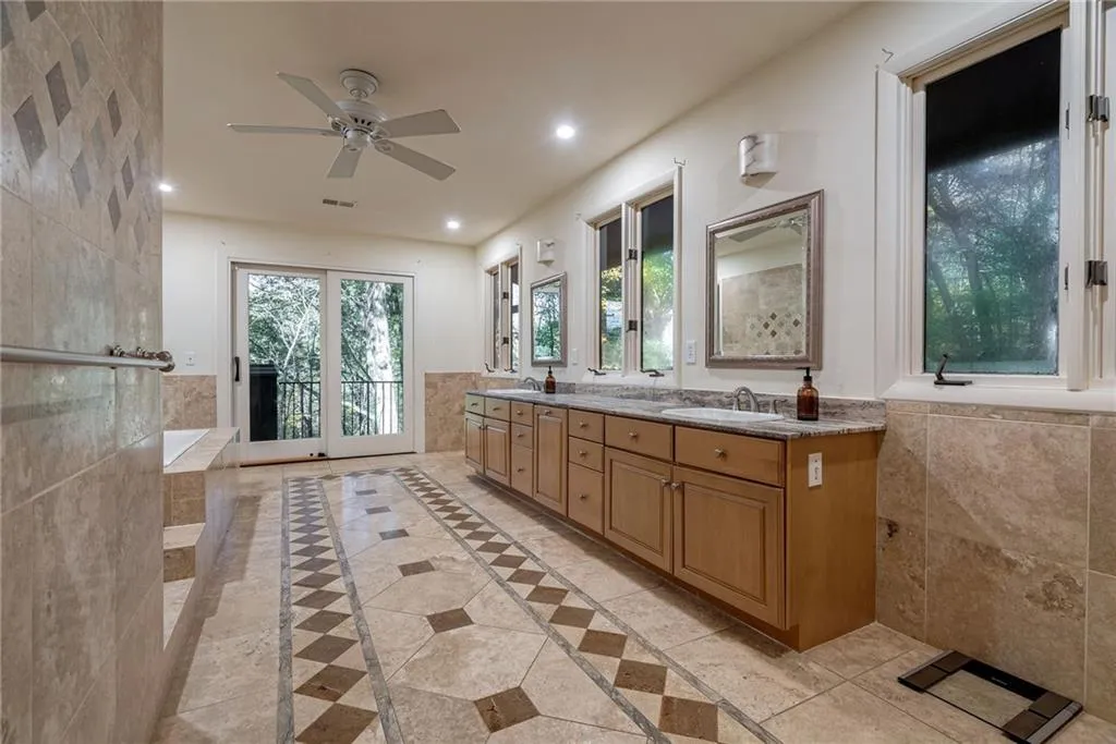Bathroom with vanity, ceiling fan, and tile walls