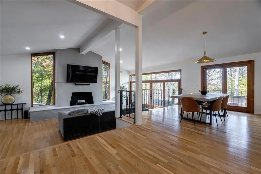 Dining area featuring a fireplace, vaulted ceiling with beams, and light hardwood / wood-style flooring
