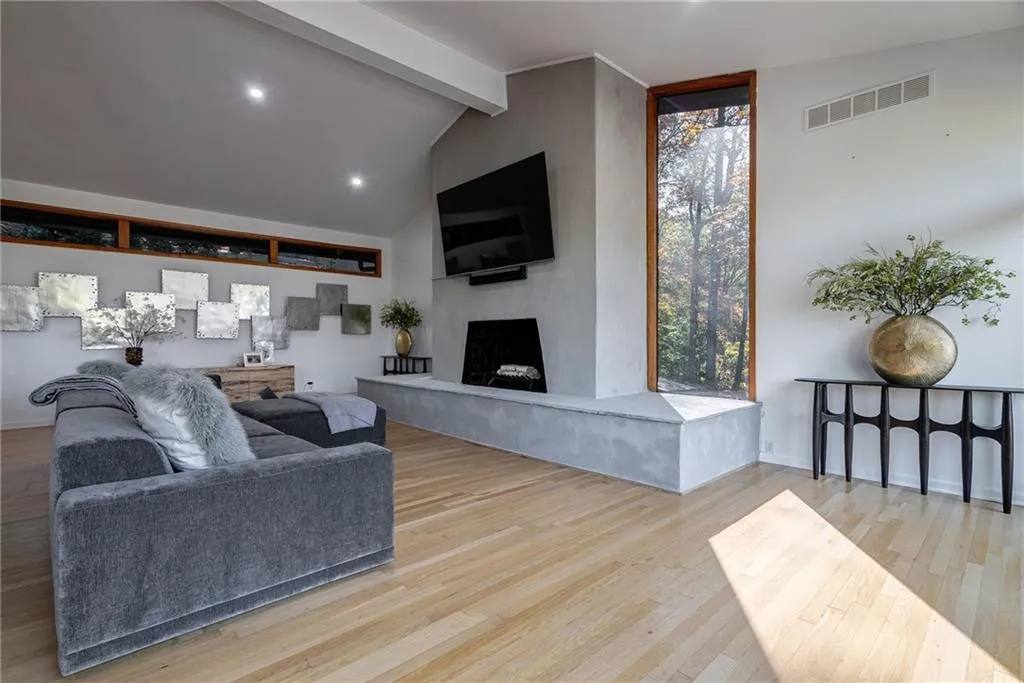 Living room featuring vaulted ceiling with beams, a healthy amount of sunlight, and light wood-type flooring