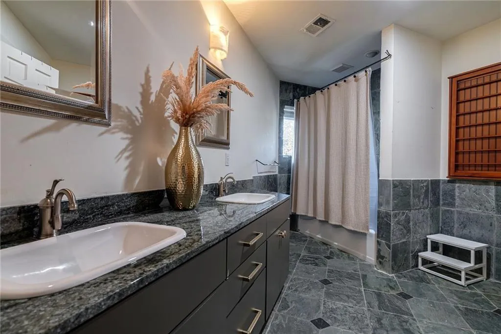 Bathroom featuring vanity and shower / bath combo with shower curtain