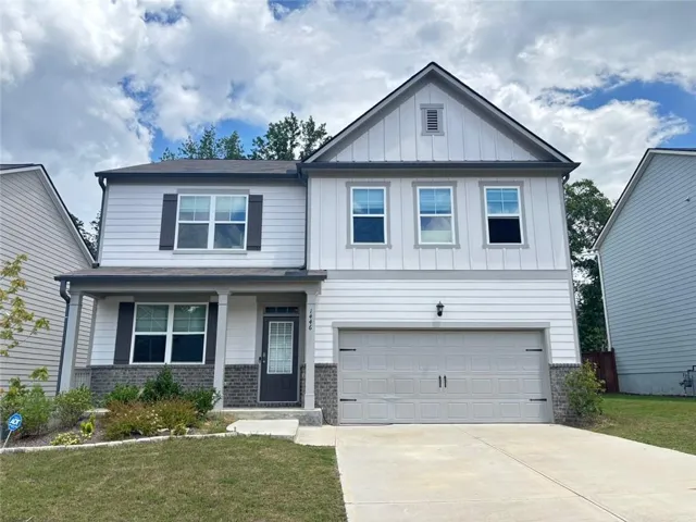 Two-story exterior with a covered front porch, attached two-car garage, and a concrete driveway