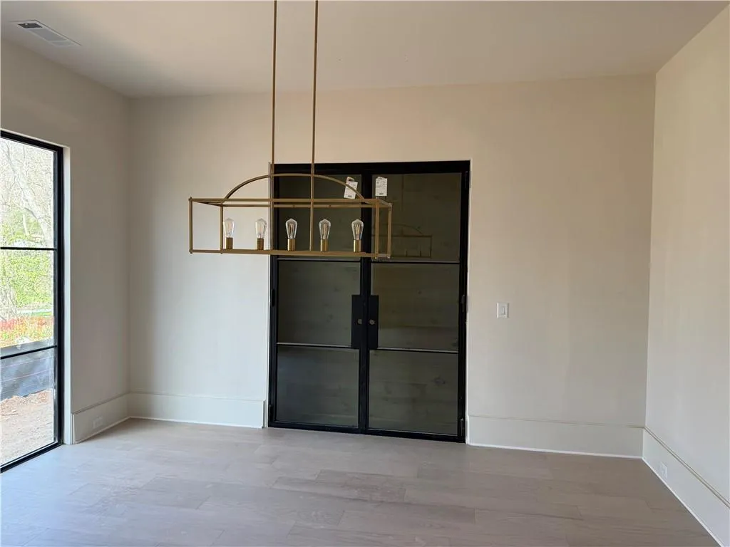 Unfurnished dining area featuring light wood-style flooring and baseboards