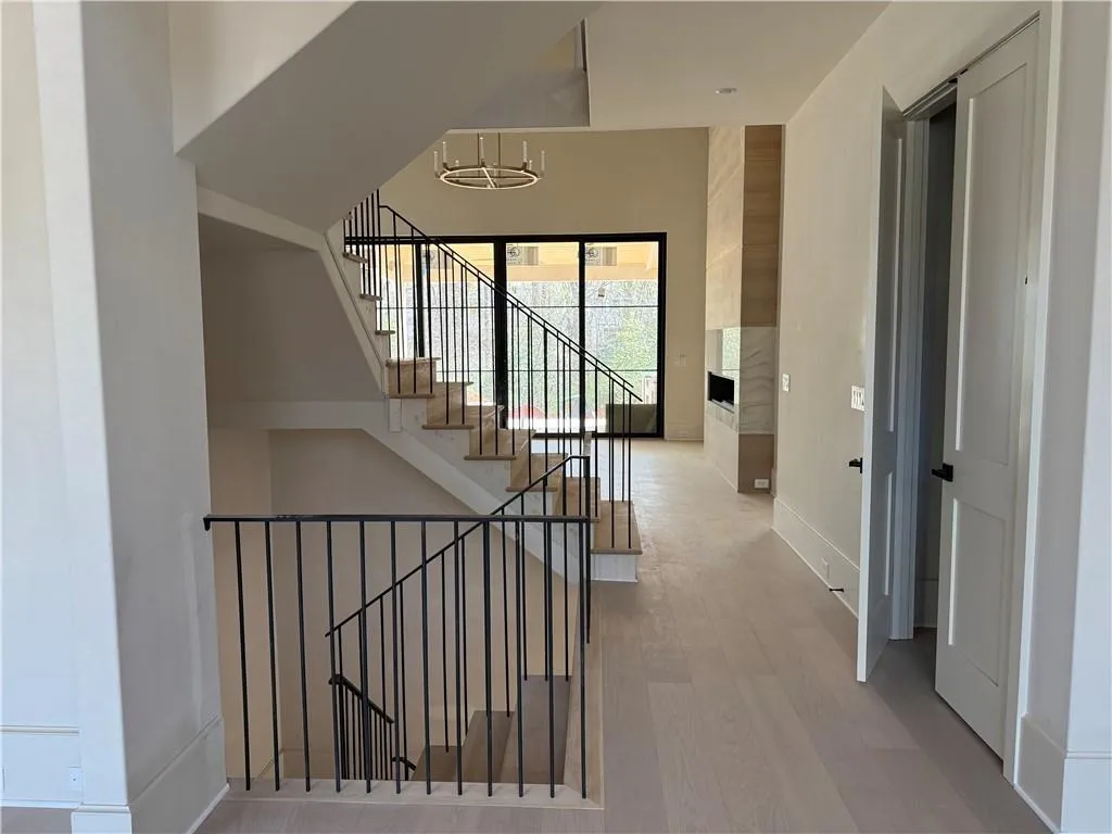 Stairs with wood finished floors, a high ceiling, and suspended lighting