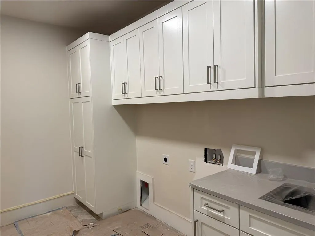 Laundry room featuring electric dryer hookup, cabinet space, and washer hookup