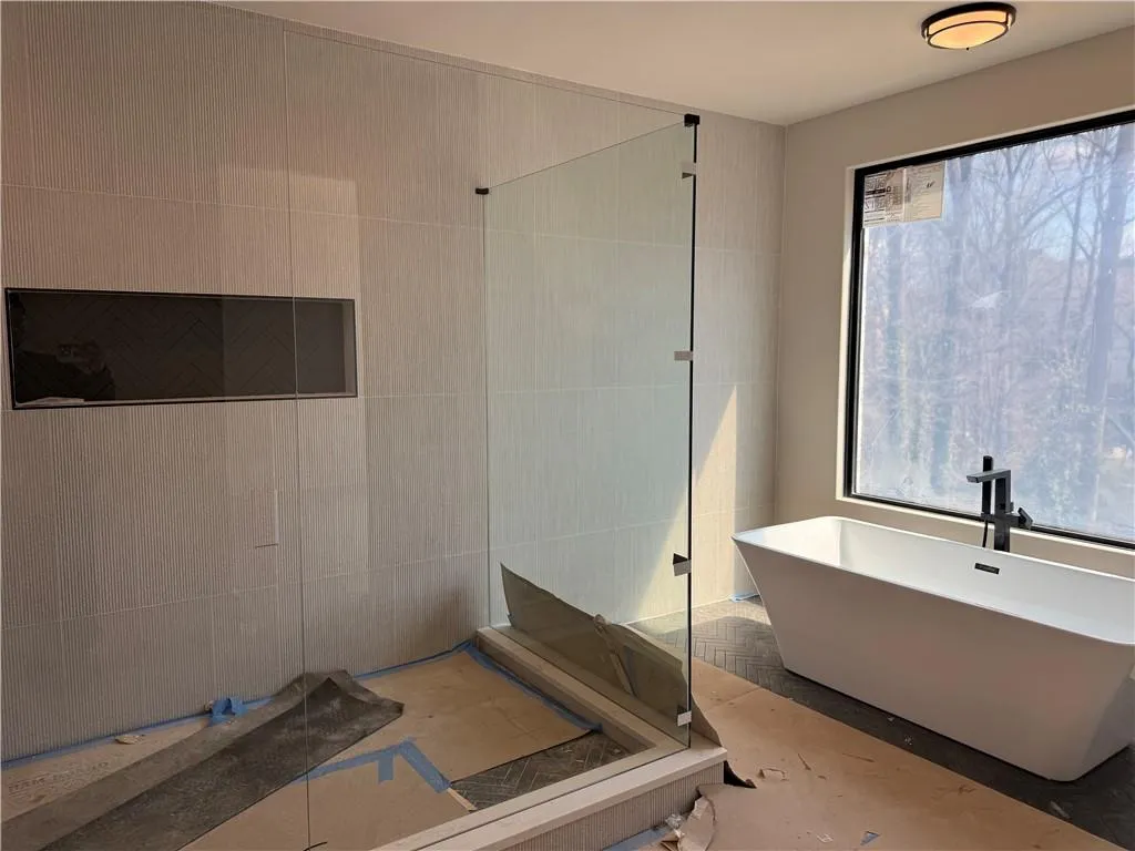 Full bath with tiled shower and a freestanding bath