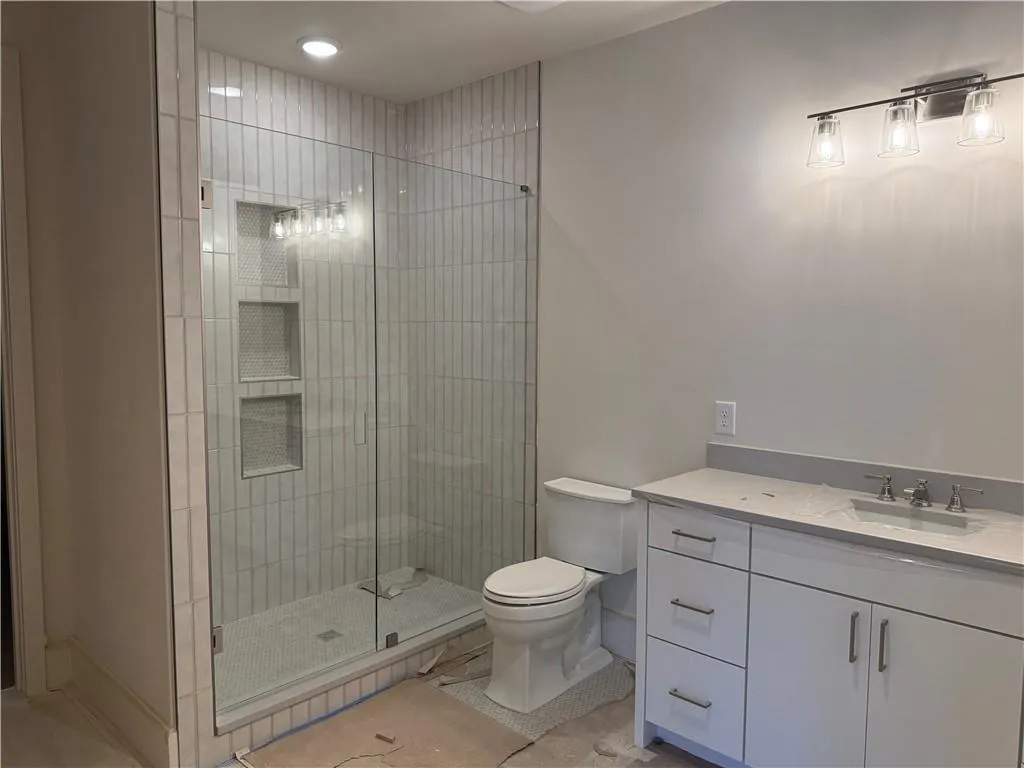 Full bath featuring vanity, a stall shower, and light tile patterned floors