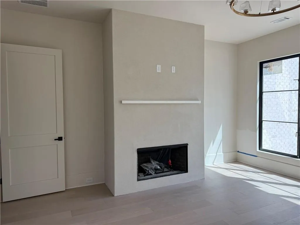 Unfurnished living room featuring light wood-type flooring and a fireplace