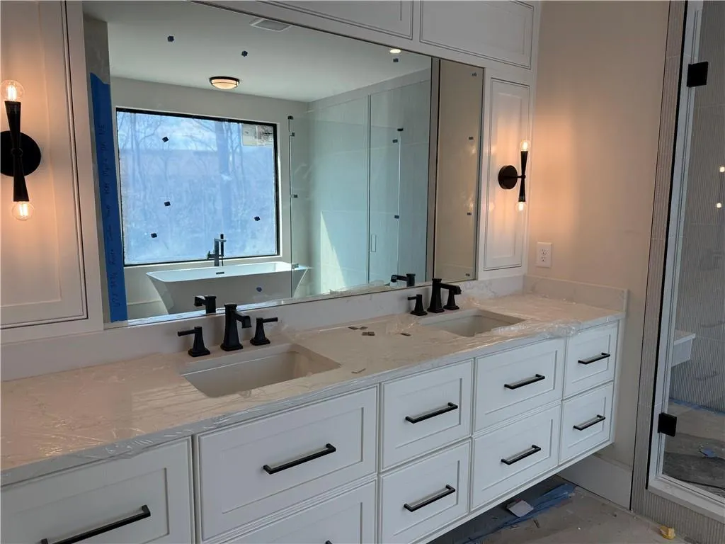 Bathroom with double vanity, a shower stall, and a soaking tub