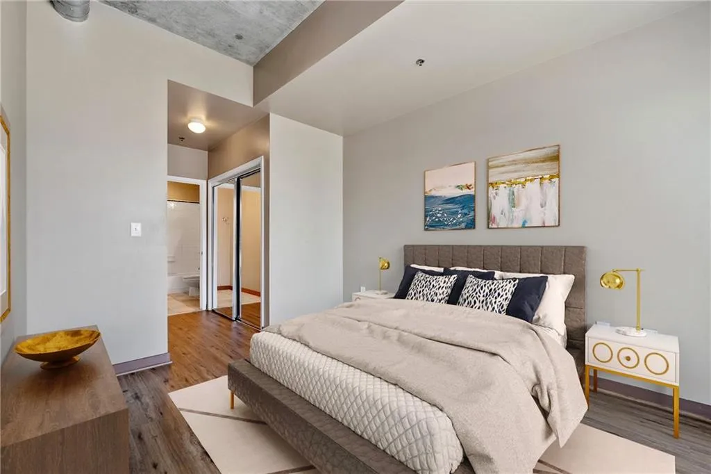 Bedroom featuring wood finished floors, baseboards, and connected bathroom