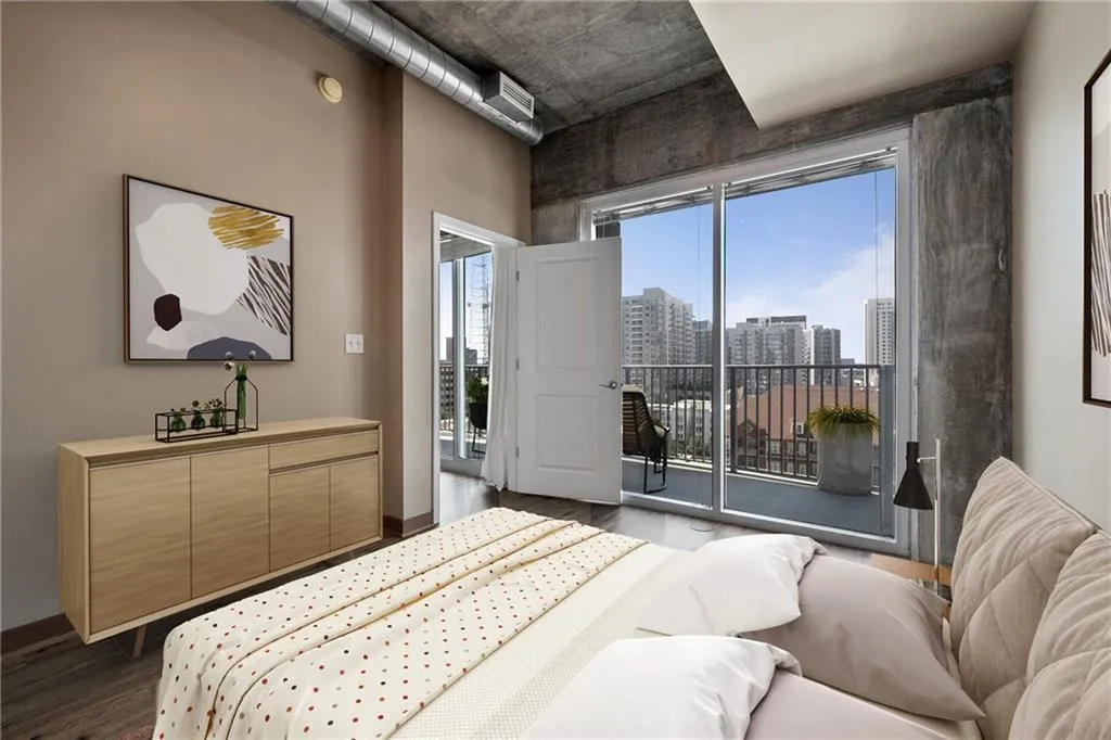 Bedroom featuring dark wood finished floors, access to exterior, a view of city, and baseboards