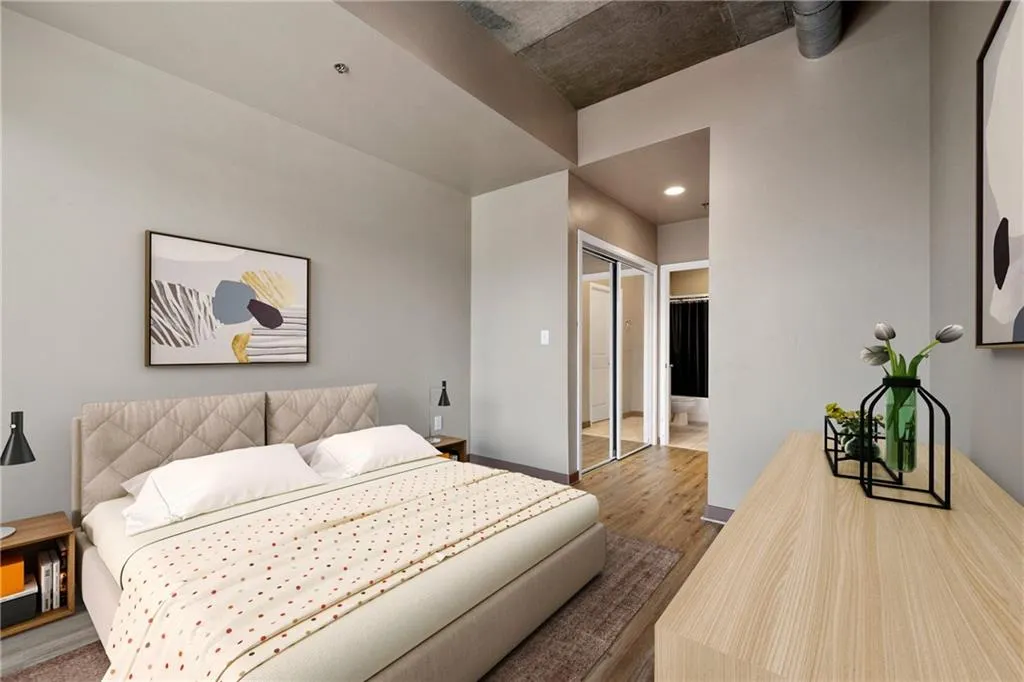 Bedroom featuring wood finished floors, baseboards, ensuite bath, and a closet