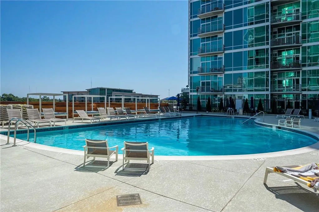 Community pool featuring a patio area and fence