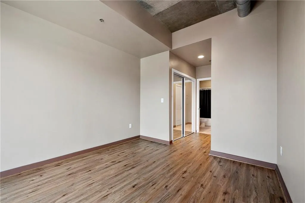 Bedroom with wood finished floors, baseboards, and recessed lighting