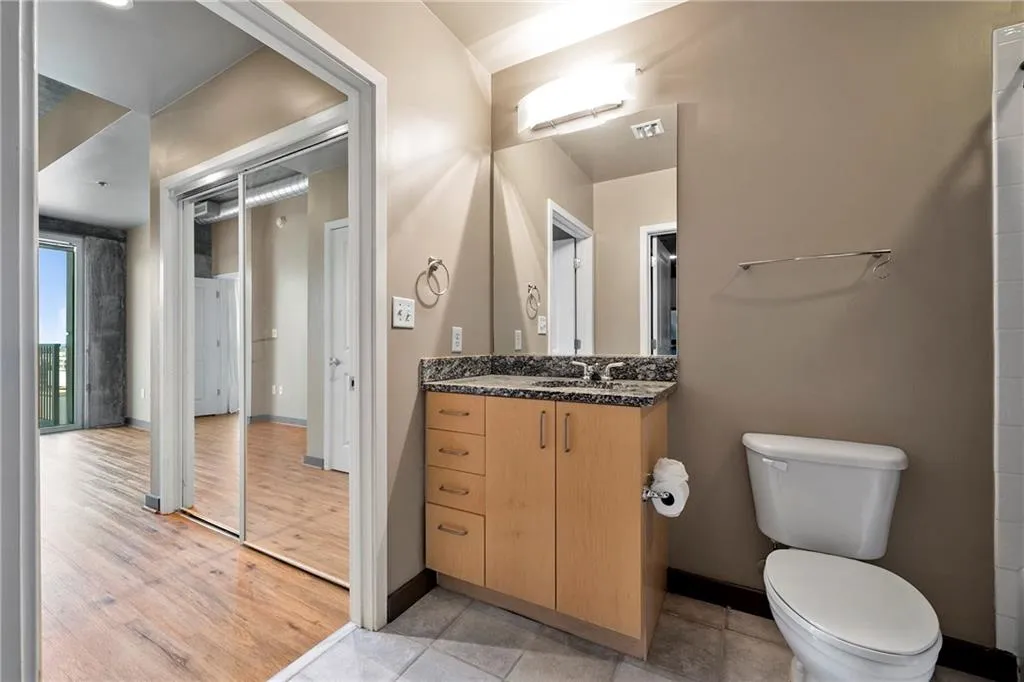 Bathroom featuring toilet, wood finished floors, baseboards, and vanity