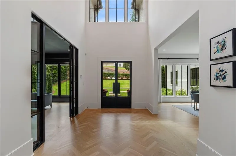 Grand foyer with double-height ceiling and hardwood herringbone flooring