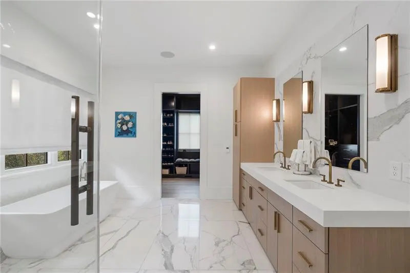 Bathroom featuring a dual vanity with light wood-finish cabinetry, solid surface countertops, and rectangular undermount sinks