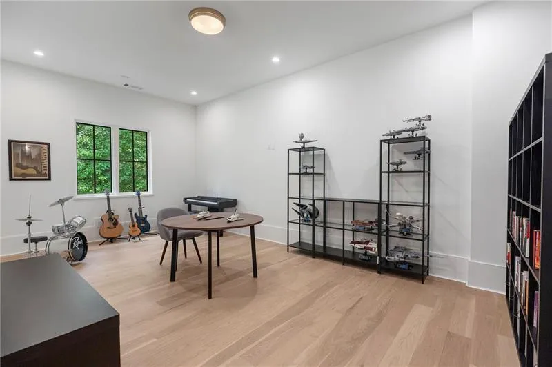 Spacious room featuring light wood-finish flooring, recessed lighting, and a contemporary ceiling fixture