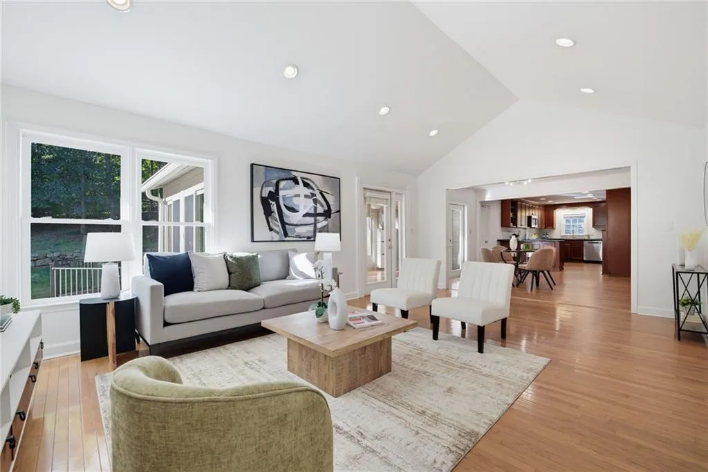 Vaulted ceilings, wood-finish flooring, recessed lighting, and expansive windows