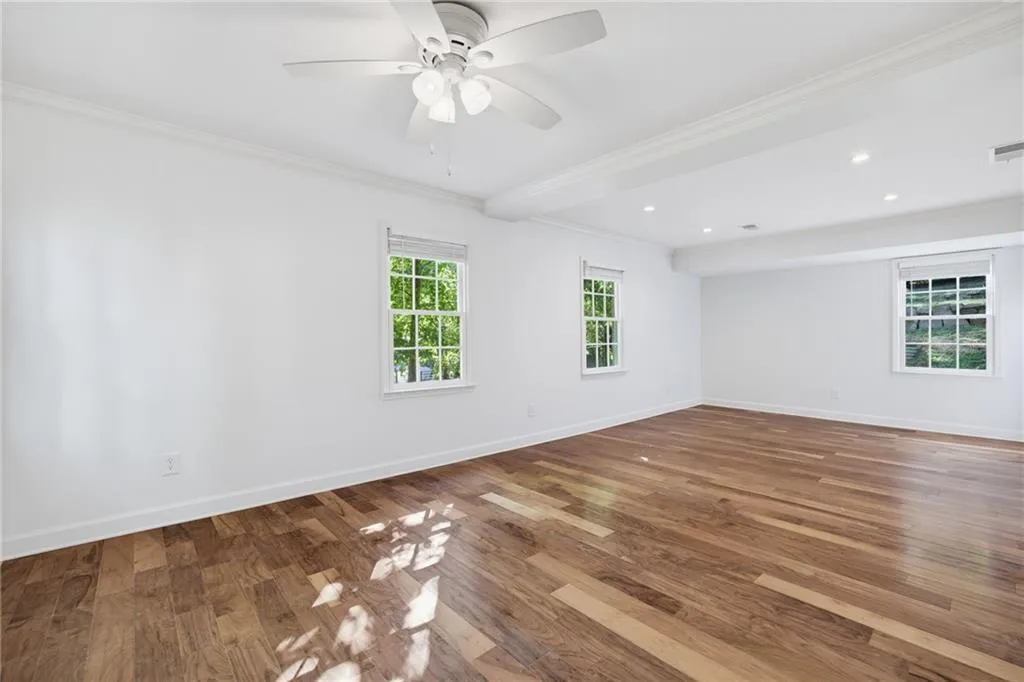 Wood-finish flooring, multi-light ceiling fan, recessed lighting, and white multi-pane windows