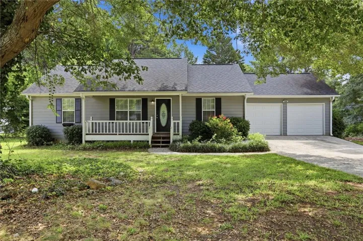 Ranch-style exterior with gray siding, a covered front porch, and a two-car garage