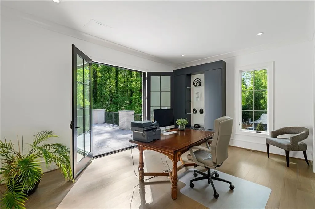 One of two bedrooms on the main level, currently being used as a home office. Private doors from the room access a balcony.
